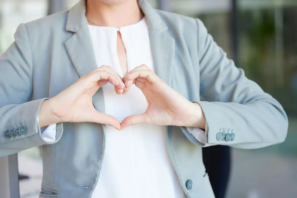 Image of woman making heart symbol with hands